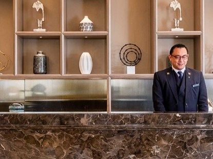 Réceptionniste en uniforme derrière le comptoir d